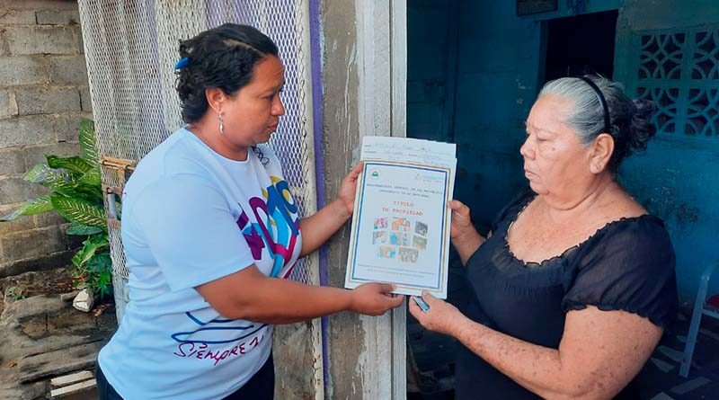 Promotores de la PGR y Juventud Sandinista entregan su título de propiedad a una pobladora de Managua