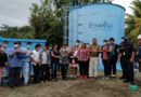 Personas delante de un tanque de agua, en la inauguración del proyecto