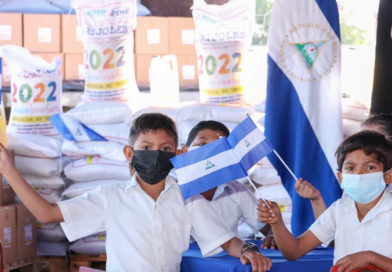 Estudiantes junto a sacos de la Merienda Escolar 2022