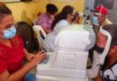 Agentes de salud en jornada especial de salud visual en el barrio 19 de Julio, realizando examen de la vista a protagonista